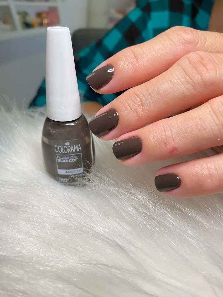 Unhas cor de chocolate com um ponto de brilho, ao lado do esmalte Colorama