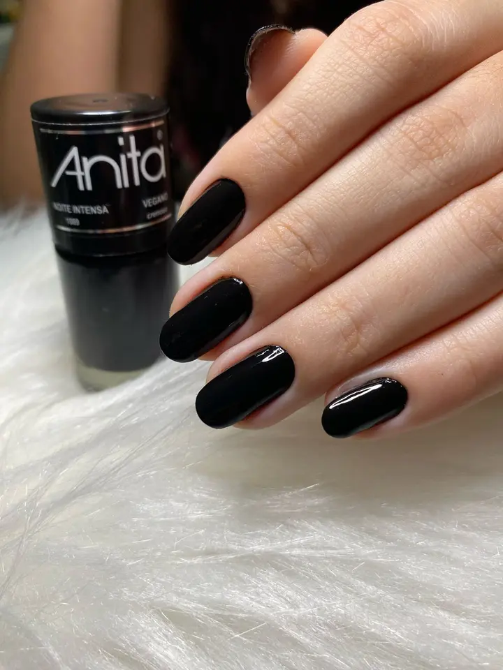 Unhas pretas brilhantes ao lado do esmalte Anita Noite Intensa